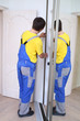 © Pavel Losevsky - Worker fixing mirrored doors on corner sliding wardrobe in room