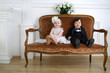 © Pavel Losevsky - Little beautiful lady in white long dress and her friend in black suit sitting on couch