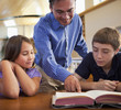 © Marc Romanelli/Blend Images - Teacher talking to students in library