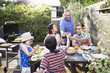 © Hello Lovely/Blend Images - Family toasting each other at table outdoors