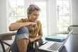 © Kevin Dodge/Blend Images - Woman using laptop in living room