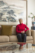 © Don Mason/Blend Images - Chinese woman sitting on sofa
