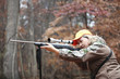 © Shestock/Blend Images - Hunter in camouflage aiming rifle in forest