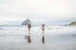 © Inti St Clair/Blend Images - Mixed race sisters running on beach