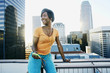 © Peathegee Inc/Blend Images - Black woman listening to earbuds on urban rooftop