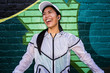 © Adam Hester/Blend Images - Asian runner standing near graffiti wall