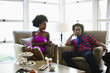 © Eric Raptosh Photography/Blend Images - African American woman sitting at cocktail party with boyfriend