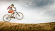 © Sollina Images/Blend Images - Mixed race boy riding dirt bike on track