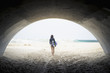 © Alberto Guglielmi/Blend Images - Caucasian woman carrying skimboard under arch