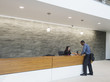 © Erik Isakson/Blend Images - Businessman talking to receptionist at office front desk