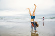 © Inti St Clair/Blend Images - Mixed race girl doing handstand on beach