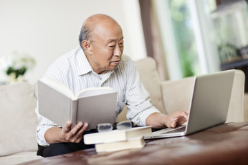 Chinese man with book and laptop