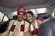 © Jihan Abdalla/Blend Images - Indian bride and groom in traditional clothing in car