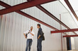 © Sollina Images/Blend Images - Men talking outside manufacturing plant