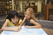 © Sam Bloomberg-Rissman/Blend Images - Girls looking at atlas in library