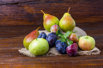 plum, apple and pear - summer fruit on wooden background