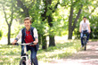 © Africa Studio - Cute boy with father on bike ride in park