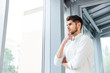 © Drobot Dean - Man standing near the window and thinking