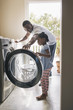 © Hello Lovely/Blend Images - African American father and daughter doing laundry