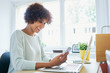 © baranq - Woman using her cellphone, working from home office
