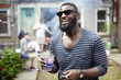 © Granger Wootz/Blend Images - African American man drinking at backyard barbecue