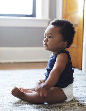 African American Baby Sitting On Floor