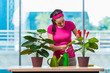 © Elnur - Young woman taking care of home plants