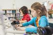 © Marc Romanelli/Blend Images - Caucasian children using laptops in library