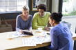© Resolution Productions/Blend Images - Business people using digital tablet in office meeting