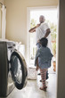 © Hello Lovely/Blend Images - African American father and daughter doing laundry