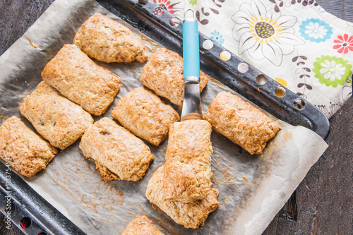 Valokuva baked pies with chocolate filling on a baking sheet and colored