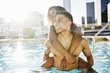 © Peathegee Inc/Blend Images - Smiling couple enjoying urban swimming pool