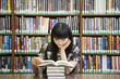 © Sam Bloomberg-Rissman/Blend Images - Smiling woman reading book in library