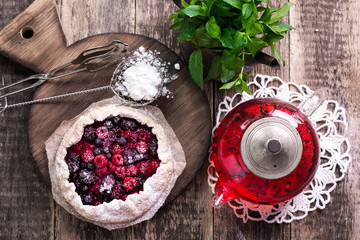 Wall Mural - Blueberry,cherry,raspberry and blackcurrant galette on w wooden background.