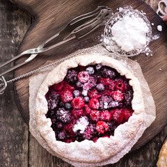 Blueberry,cherry,raspberry and blackcurrant galette on w wooden background.