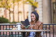 © Mike Kemp/Blend Images - Indian woman reading booklet at outdoor cafe