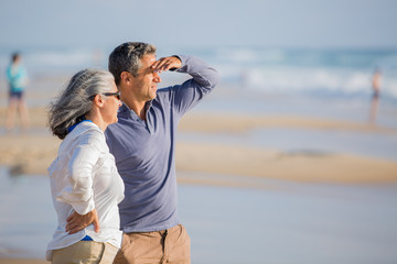 Wall Mural - mid aged couple laying out on the beach