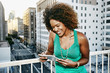 © Peathegee Inc/Blend Images - Mixed race woman using digital tablet on urban rooftop