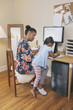 © Hello Lovely/Blend Images - African American mother with daughter working from home