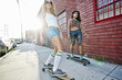 © Peathegee Inc/Blend Images - Women riding skateboards on city street
