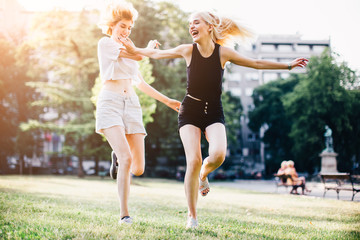 Two happy female friends having fun at the park