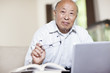 © Take A Pix Media/Blend Images - Chinese man with book and laptop