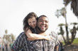 © Eric Raptosh Photography/Blend Images - Grinning man giving wife piggyback ride