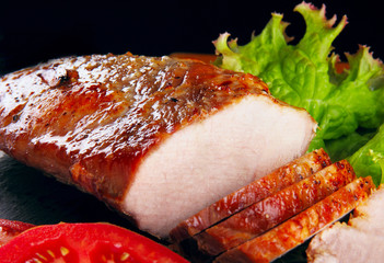 Baked pork fillet, rings of tomato leaf of salad,green onion fre