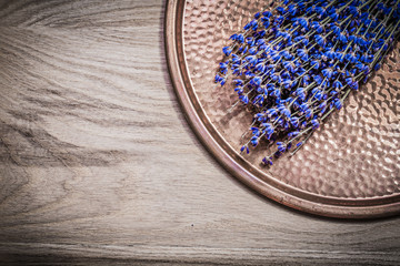 Bundle of dry scented lavender copper tray on wooden board healt