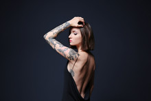 Beautiful Young Woman With Tattoo Posing On Gray Background