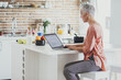 © Lumina Images/Blend Images - Older Caucasian woman using laptop in kitchen
