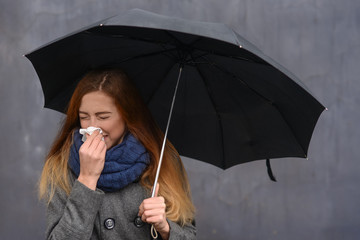 Woman sneezing handkerchief outdoor in autumn