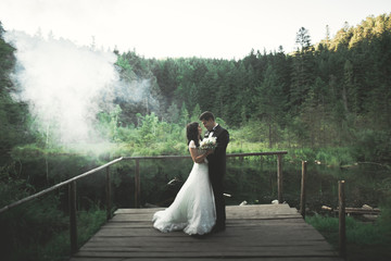 Wedding couple, bride, groom posing on pier