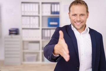 Poster - mann im büro reicht die hand zur begrüßung..